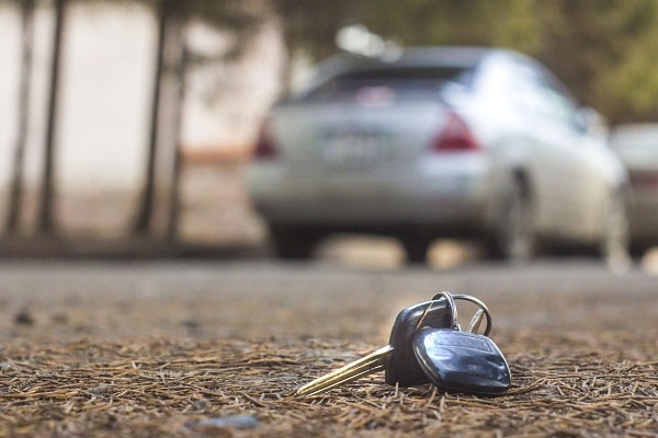 a set of car keys sits forgotten on the ground outside behind a car